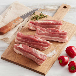 cuatro piezas de tocino carnudo de cerdo marca sagal en una tabla de cortar