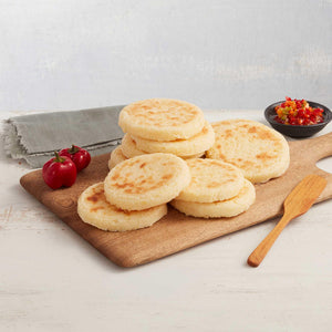 Arepas de maíz peto y queso crema marca San Jorge sobre una tabla de cortar decoradas con especias
