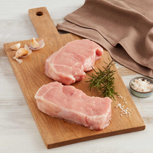 Dos Bifes de Lomo de Cerdo Crudos Marca Sagal Sobre Tabla de Cortar y Adornados con Especias