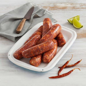 Porción de Chorizo Artesanal Picante Marca Sagal Servidos en un Plato y Acompañados de Limón