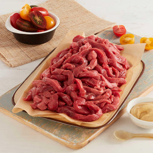 Julianas Finas de Res Crudas marca Sagal sobre un plato y decoradas con tomates