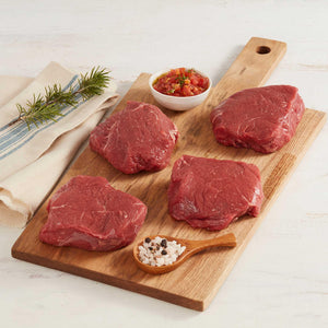 Cuatro Medalliones de Lomo de cuadril de Res Marca Sagal Crudos sobre Tabla de Cortar Adornados con Especias