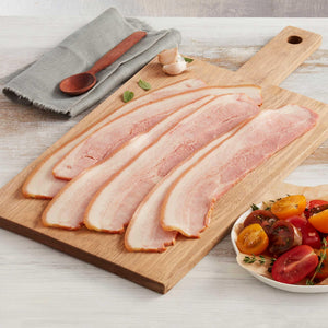 Seis Lonjas de Tocineta Ahumada de Cerdo Marca Sagal sobre una Tabla de Cortar Adornado con Tomates Cherry